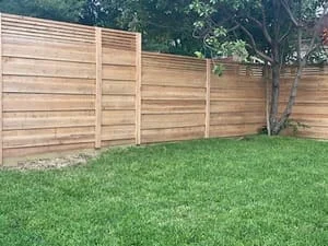 Horizontal cedar privacy fence with clean slat design installed along residential yard perimeter