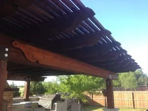 Timber pergola with exposed beams and slat roof over patio area
