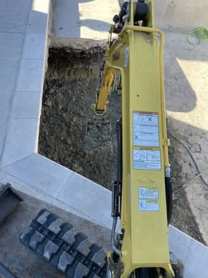 Concrete block retaining wall with gravel backfill and drainage system