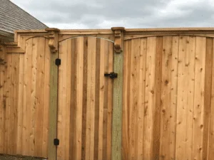 Vertical cedar privacy fence with black hardware and post caps