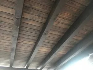 Wooden beam patio ceiling with horizontal slats and concrete support columns