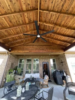 Covered patio with vaulted wood ceiling, exposed beams, ceiling fan, and brick columns