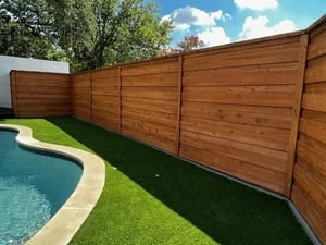 Horizontal wood privacy fence with synthetic turf lawn and pool area