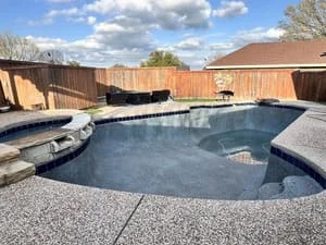 Stamped concrete pool deck with integrated coping around residential pool