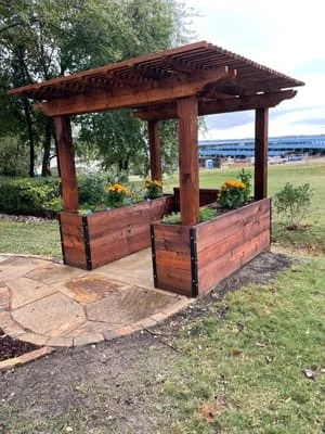 Redwood pergola with integrated planter boxes on stamped concrete patio