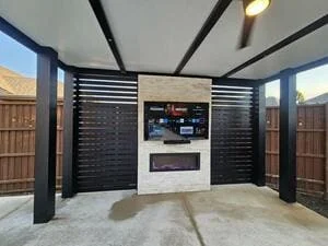 Modern pergola with black horizontal slats, built-in grill, and concrete patio