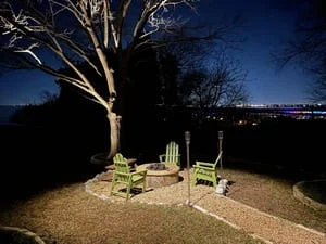 Uplighting on mature trees with ground-level landscape lighting in evening setting