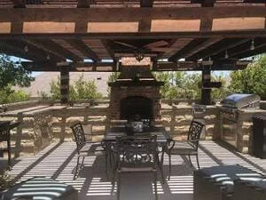 Wood pergola with fireplace, concrete patio, and outdoor seating area