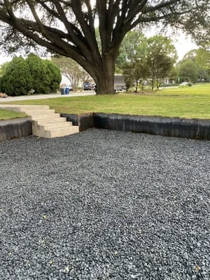 Gravel patio with timber border and stone step walkway in park setting