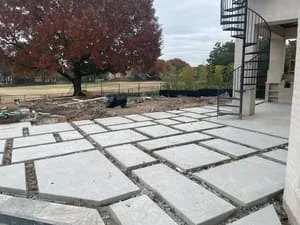 Large concrete pavers with gravel joints installed in geometric pattern on residential patio