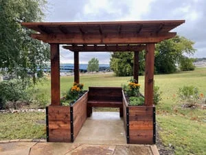 Stained timber pergola with integrated planter boxes and concrete pad foundation